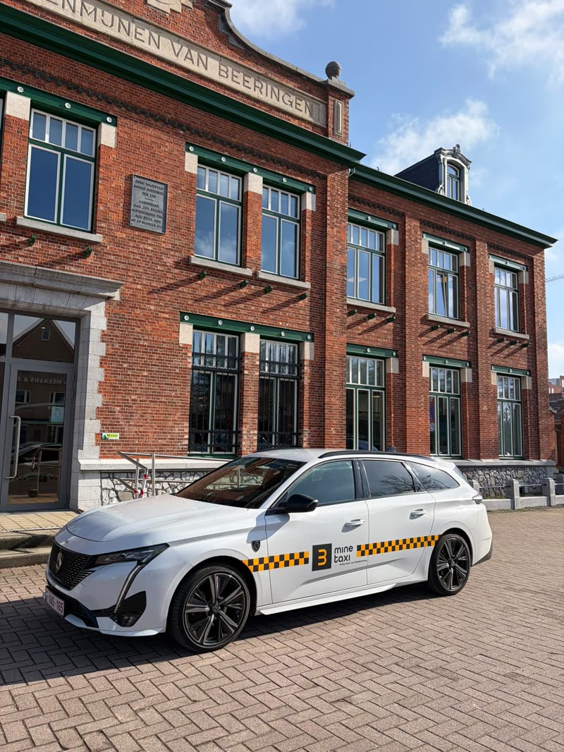Weißer BMINE-Taxi-Kombi vor dem alten Zechengebäude in Beringen
